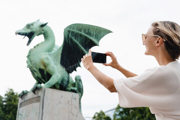 Woman taking photo on smartphone of Dragon bridge (Zmajski most), symbol of Ljubljana, Slovenia - 762270182