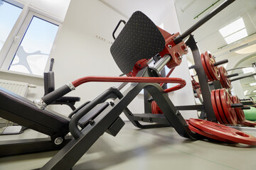 Leg press training machine in gym room.