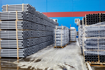 Plenty of grey plastic water pipes at outdoor storage.