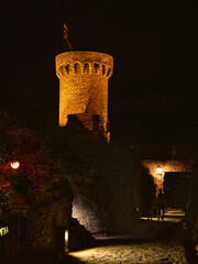 Castle tower lit up at night in small Spanish town