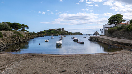Serene bay and bay in Spain with moored boats and island and trees in background