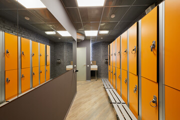 Orange lockers in locker room in sports club.