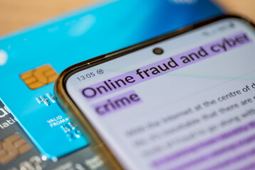 An online fraud and cyber crime concept, with a smart phone which has the words online fraud and...