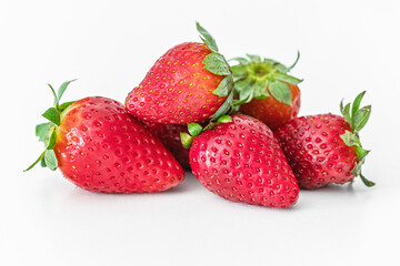 a pile of fragrant ripe strawberries on a white surface close up