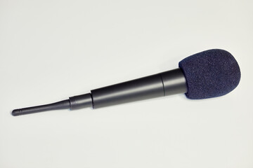 Black radio microphone with wind noise reducer.