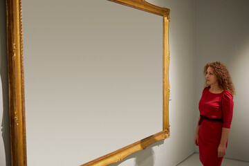 Woman looks at canvas in frame.