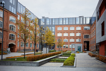 Red brick facade and garden in backyard of the business centre Bolshevik, former confectionery factory Bolshevik.