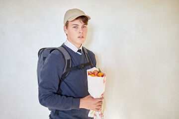 Portrait of schoolboy in cap with rucksack and bunch of flowers. © Pavel Losevsky