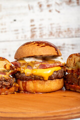 Hamburgers with cheddar cheese and special sauce on a wooden background. Close up