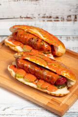 Hot dog with ketchup and yellow mustard on wood background. Close up