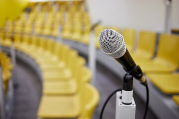 Closeup microphone on holder in conference hall, shallow dof.