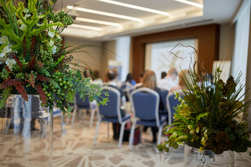 Bunches of artificial flowers and plants in auditorium, shallow dof.