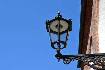 Gas street lamp, lantern. The Cathedral Island (polish: Ostrow Tumski) in Wroclaw, Poland. One of the few remaining places in Europe where a lamplighter lights the gas street lamps every evening