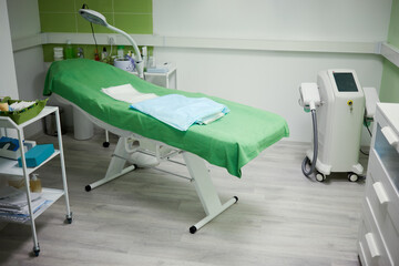 Interior of beauty parlour, green cosmetology armchair and equipment.