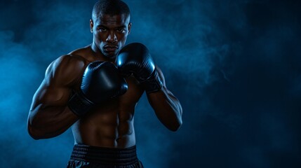 Young muscular African American man boxer with black gloves on, ready to fight. Dark blue background with smoke.