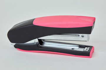 Black and pink stapler on white background.