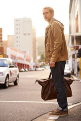 Morning, street and man in city with bag for travel, commute and journey in urban town. Fashion, walking and person with trendy style, clothes and outfit for holiday, vacation and weekend outdoors