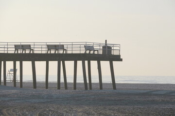 Silhouette Wooden Pier Overlooking Beach and Ocean in Early Morning