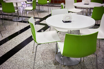 Interior of cafe with light plastic furniture.