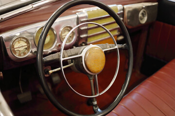 Steering wheel in old retro car with leather interior in museum