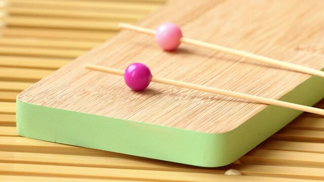man puts wooden sticks with multicolored round tips for pinchos on the board