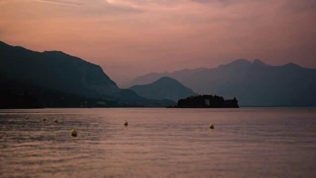 Orange sunset timelapse of Isola Bella on Maggiore Lake Italy - Boats passing 