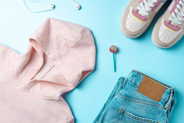 Clothes for youth on a blue background. Outfit for teenagers. Top view, flat lay.