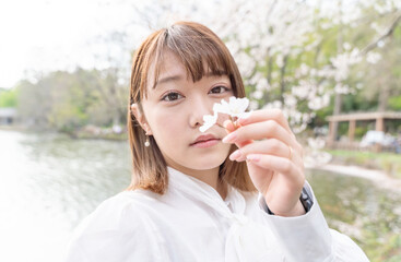 桜の花びらと見つめる女性