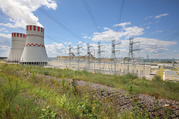 Smoking pipes, poles with wires of atomic thermal power plant at summer day
