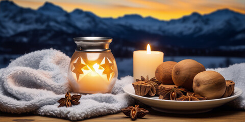 Obraz na płótnie Canvas Candle and star lantern with anise and wooden balls on a background of snowy mountains at sunset