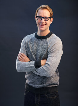 Happy, nerd and portrait of man in studio with arms crossed and pride on dark background. Confident, programmer and person with a smile in development of solution for IT project in mockup space