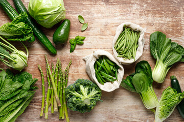 Vegetables background. Various green vegetables on kitchen table. Clean eating, healthy food concept, flat lay, top down view - 762328909