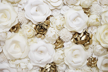 Wall with beautiful artificial white and gilt flowers, close up