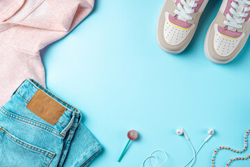 Clothes for youth on a blue background. Outfit for teenagers. Top view, flat lay.