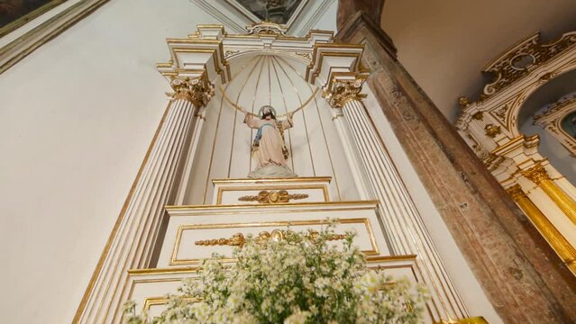 image of the resurrected Christ on the altar of a Catholic church decorated with gold and flowers. Easter, holy week