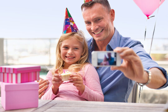 Father, child and birthday with selfie, cell phone and picture for memories or social media. Daughter, cake and presents for celebration outside, photo and screen on technology for photograph