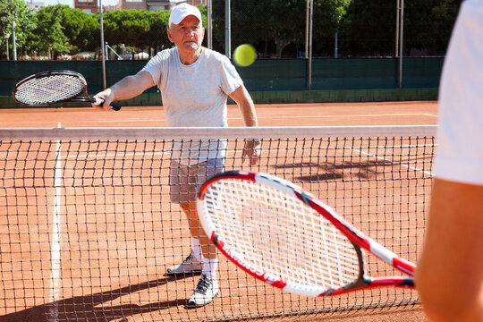 Mature sportsman playing at tennis court
