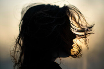 Naklejka premium Silhouette of woman's head with waving hair, back light.