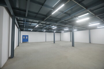 empty warehouse filled with pharma blue container rack for storage and epoxy flooring in...