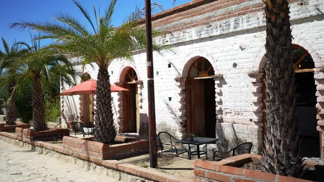 Beautiful exterior of cafe with palm trees in historical mining town of El Triunfo, Mexico.