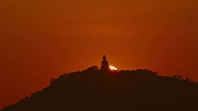.scenery The sun circles behind the Buddha on the mountain as the sun travels from the sky and falls behind the mountain. .The Sky gradually changed color from yellow to orange and red over time.