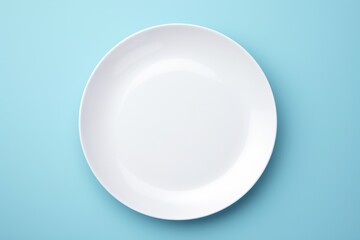 A simple white plate on a blue surface. Perfect for food or kitchen-related designs