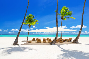 Beach chairs under a canopy on a beautiful white sand beach in Punta Cana, Dominican Republic.