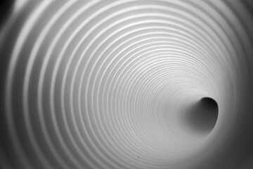 Monochrome perspective of a camera inside a white plastic evacuation tunnel, serving for air and water evacuation in emergencies.