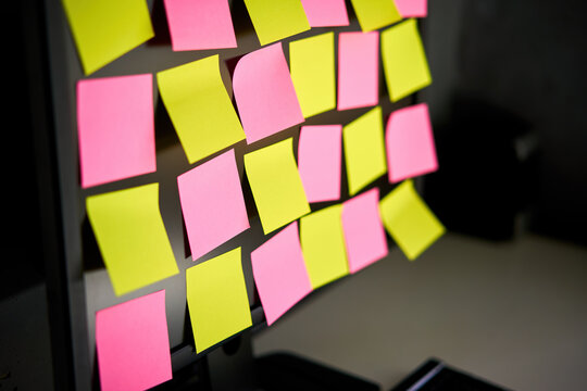 Close up colorful sticky notes reminders on computer monitor