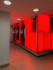 A corridor bathed in red light creates a dramatic and modern atmosphere inside a building.