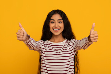 Woman giving thumbs up on yellow background
