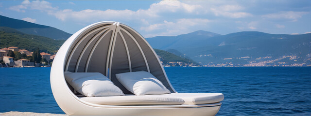 Futuristic white pod-like lounger by the sea with a beautiful landscape and blue water