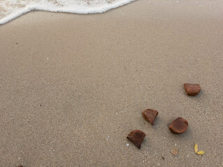 A heart drawn in the sand with footprints nearby on a tropical beach