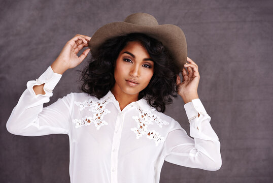 Portrait, studio and woman with cowboy fashion, confidence and relax with girl in stetson hat. Rodeo, western style and face Mexican model with cowgirl culture, wild west clothes and grey background